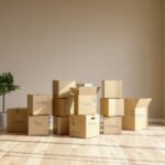 Moving In Or Moving Out A House. Books, Toys, Kitchen Utensils And Other Equipment Are In Cardboard Boxes In Empty Room.